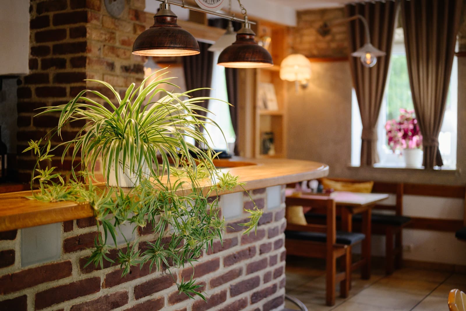 Backsteinbar mit Grünpflanze und warmem Kupferlicht im Restaurant