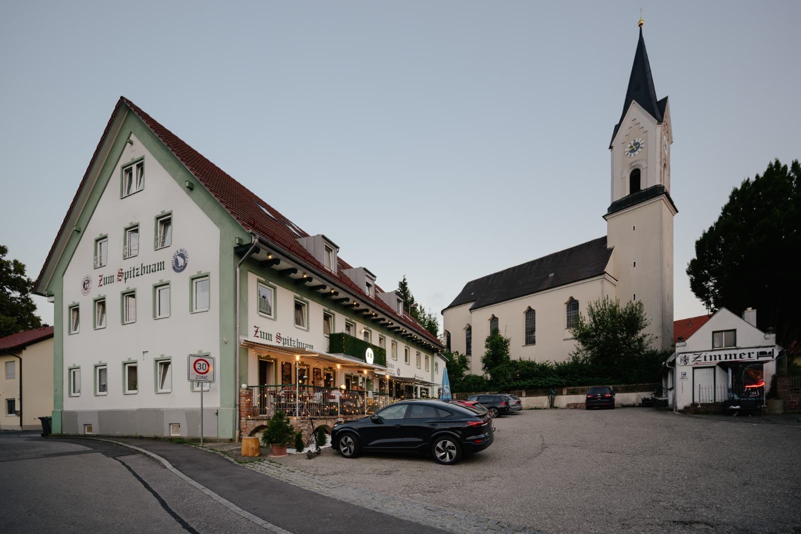Blick über den Dorfplatz von Attenkirchen mit Kirche und Gasthaus