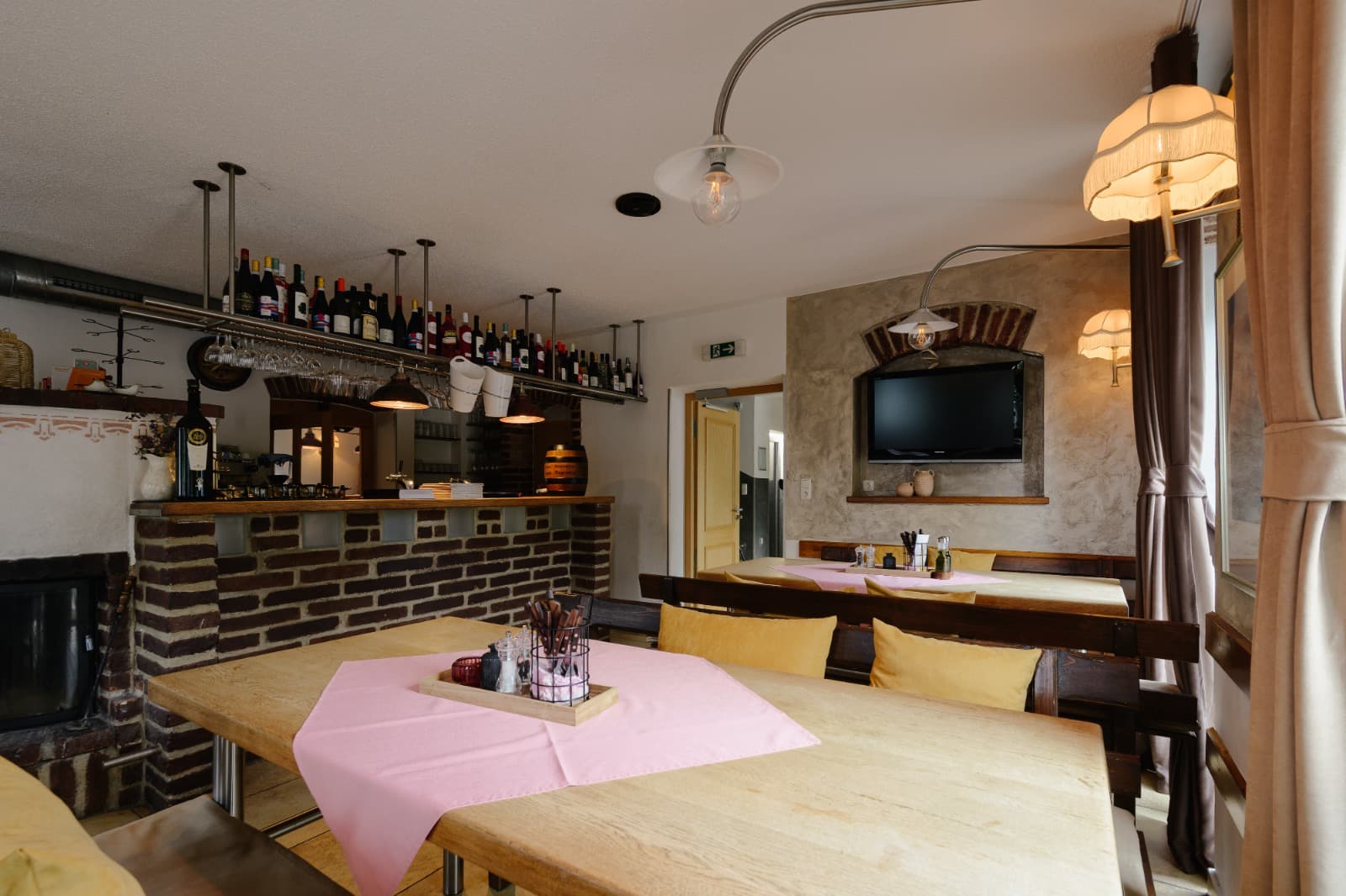 Backsteinbar mit Flaschenregal und gedeckten Tischen